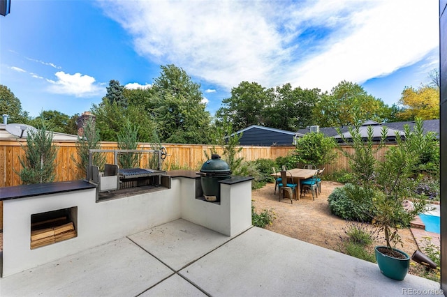 view of patio featuring an outdoor kitchen, a fenced backyard, grilling area, and outdoor dining area