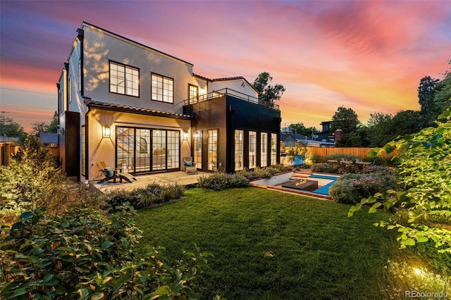 back of house featuring a patio, stucco siding, a balcony, and french doors