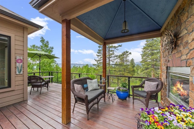 12653 Rancho Ct, Conifer, CO 80433 - wooden deck with an outdoor stone fireplace