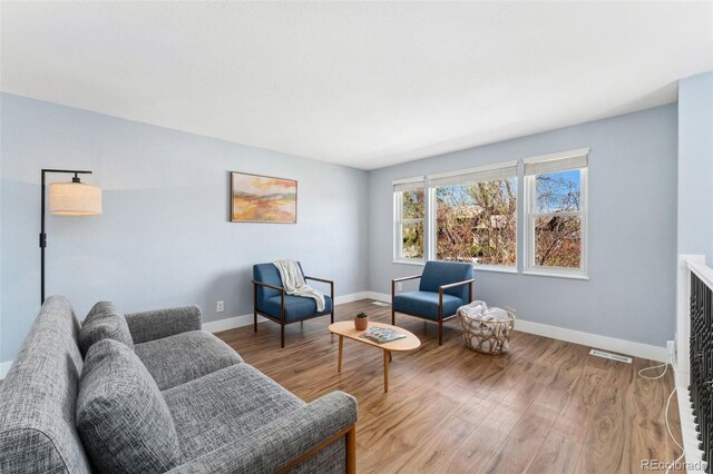 sitting room featuring visible vents, wood finished floors, and baseboards