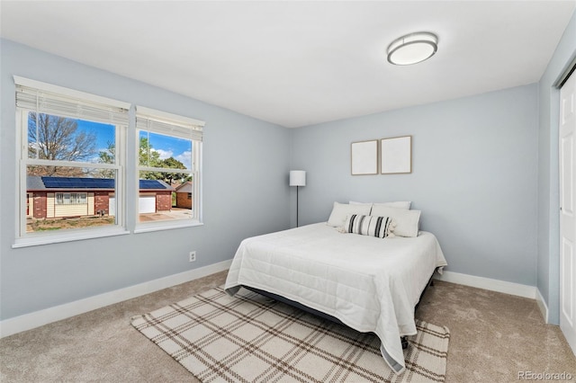 bedroom featuring light carpet and baseboards