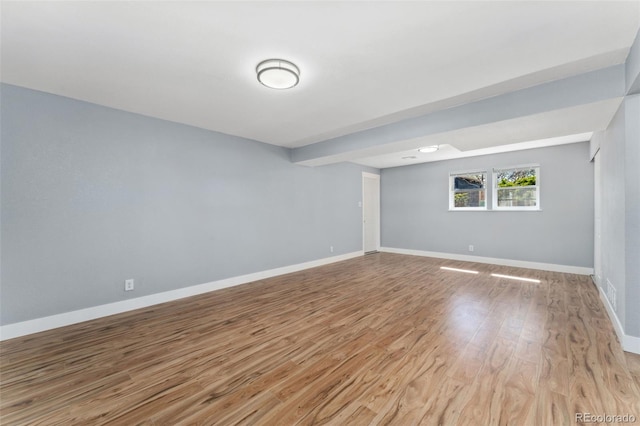 unfurnished room with baseboards and wood finished floors