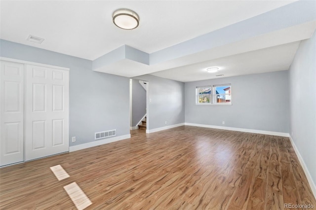 interior space featuring visible vents, wood finished floors, baseboards, and stairs