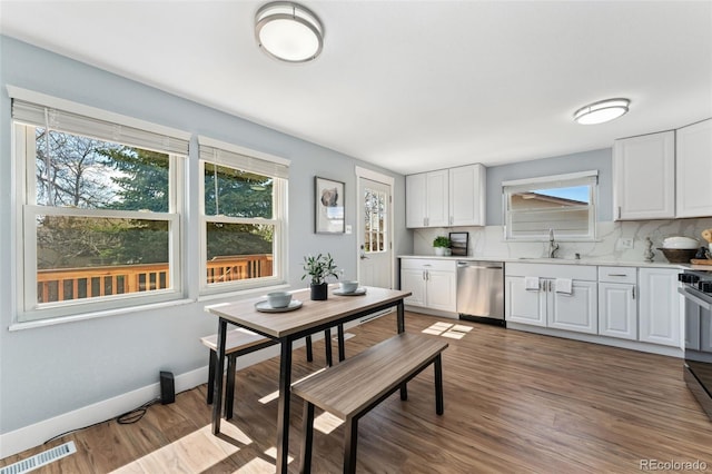 kitchen featuring a sink, visible vents, dishwasher, white cabinetry, and light countertops