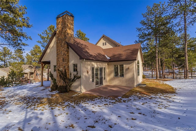 view of snow covered rear of property