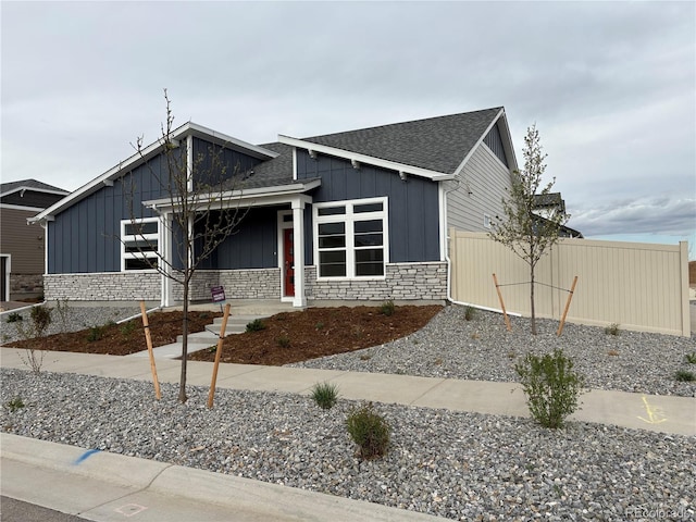 view of front of house featuring board and batten siding, a shingled roof, and stone siding