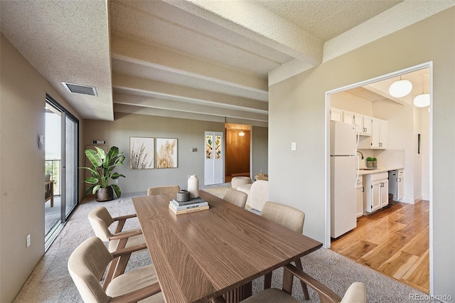 7865 E Mississippi Ave Unit 1504, Denver, CO 80247 - dining area with beam ceiling, a textured ceiling, and light wood-style floors