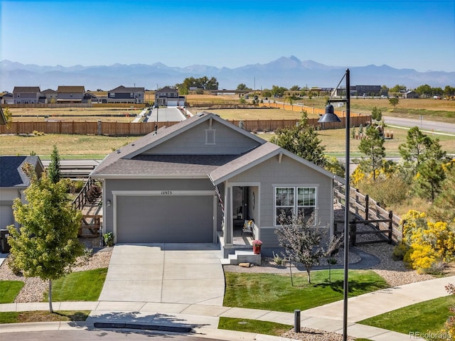 view of front of home featuring a garage, a mountain view, and a front lawn