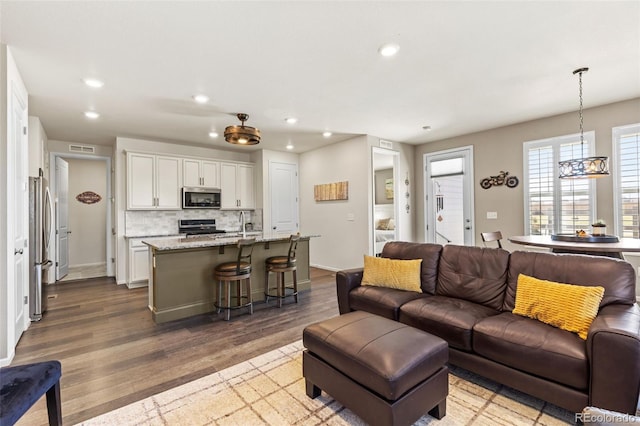 living room with a notable chandelier and hardwood / wood-style floors