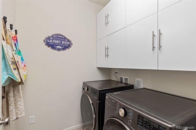 laundry room with washing machine and clothes dryer and cabinets