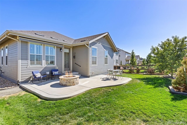 back of house with a lawn, a patio, and an outdoor fire pit