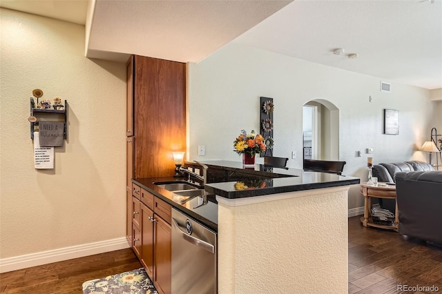 kitchen with a sink, brown cabinets, dark wood-type flooring, dishwasher, and arched walkways