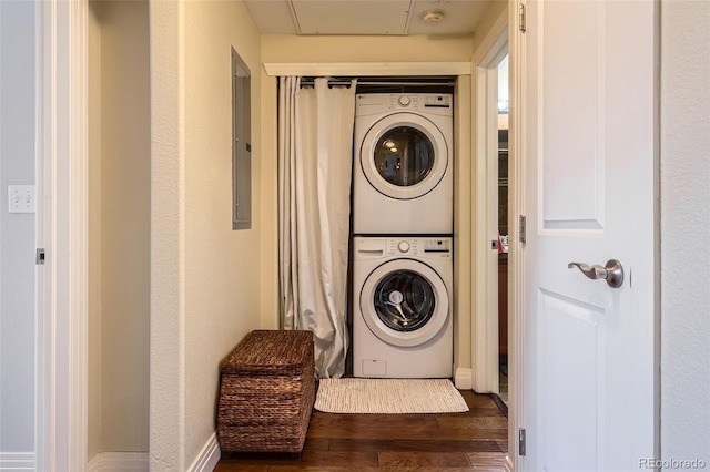 washroom with stacked washer / dryer, wood finished floors, electric panel, and attic access