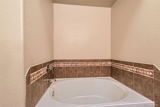 9019 E Panorama Cir Unit D207, Englewood, CO 80112 - full bathroom featuring a textured wall and a garden tub