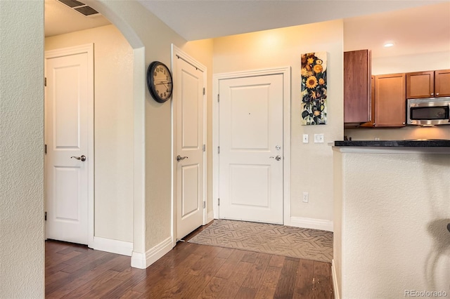 9019 E Panorama Cir Unit D207, Englewood, CO 80112 - kitchen featuring stainless steel microwave, dark wood-type flooring, arched walkways, baseboards, and recessed lighting