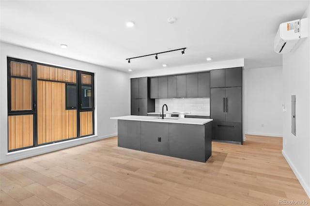 1601 Park Ave Unit 307, Denver, CO 80218 - kitchen featuring a wall unit AC, track lighting, modern cabinets, a sink, and decorative backsplash