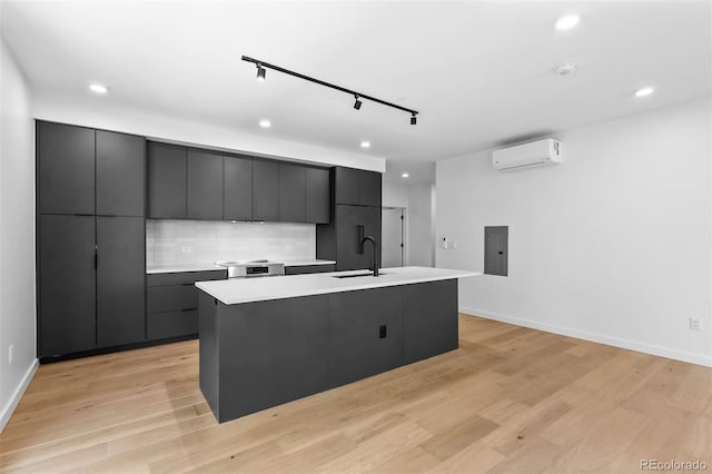 1601 Park Ave Unit 307, Denver, CO 80218 - kitchen with a wall mounted air conditioner, a sink, modern cabinets, recessed lighting, and an island with sink
