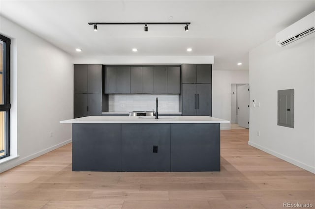 1601 Park Ave Unit 307, Denver, CO 80218 - kitchen featuring electric panel, a sink, a wall mounted AC, an island with sink, and recessed lighting