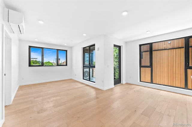 1601 Park Ave Unit 307, Denver, CO 80218 - unfurnished room with a wall unit AC, light wood finished floors, baseboards, and recessed lighting