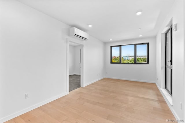 1601 Park Ave Unit 307, Denver, CO 80218 - unfurnished bedroom featuring an AC wall unit, light wood-style floors, recessed lighting, and baseboards