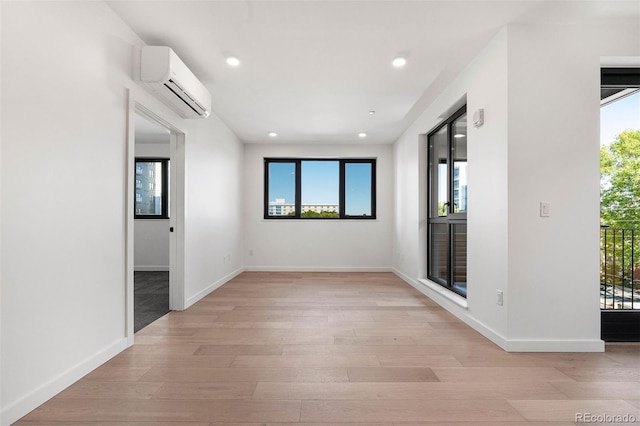 1601 Park Ave Unit 307, Denver, CO 80218 - spare room featuring a wall mounted air conditioner, healthy amount of natural light, light wood-type flooring, recessed lighting, and baseboards