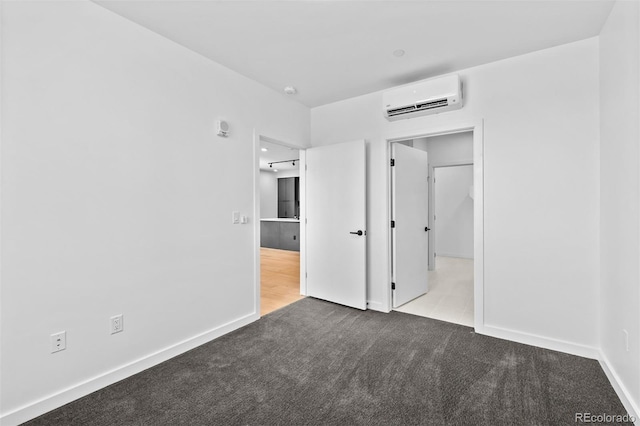 1601 Park Ave Unit 307, Denver, CO 80218 - unfurnished bedroom featuring a wall mounted air conditioner, carpet flooring, and baseboards