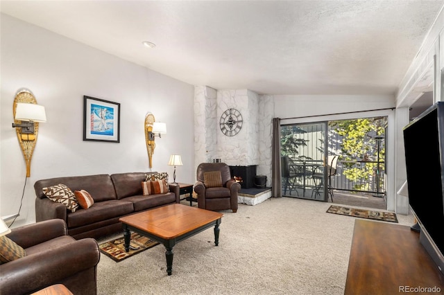 carpeted living room featuring a textured ceiling, vaulted ceiling, and a fireplace