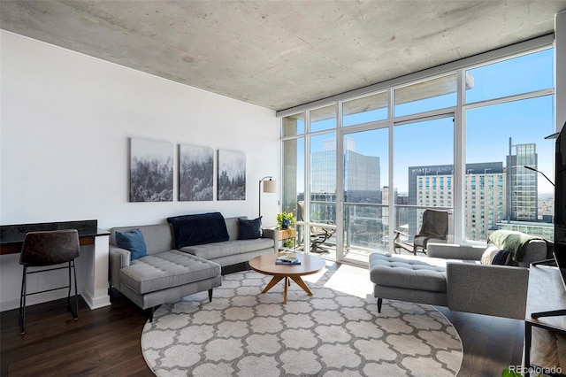 living area with dark wood-style flooring, a wall of windows, and a view of city