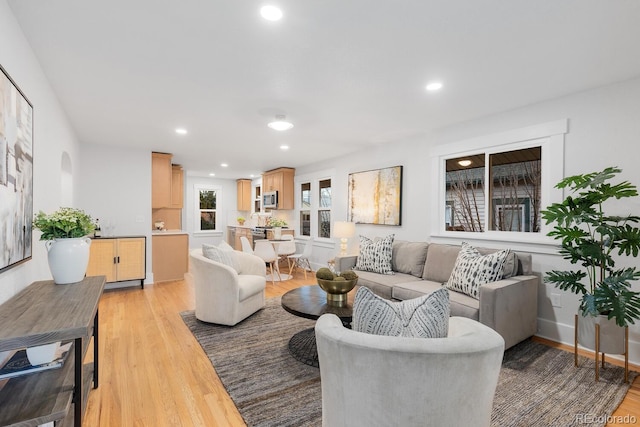 living area featuring light wood-style flooring, recessed lighting, and baseboards