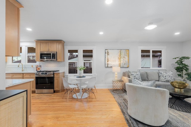 living room with plenty of natural light, recessed lighting, and light wood finished floors