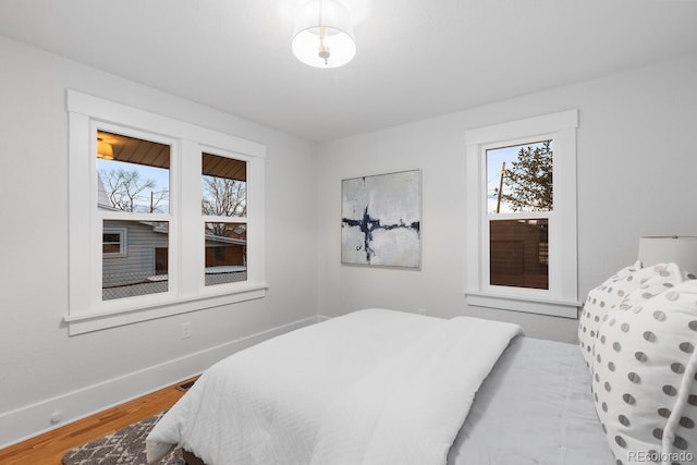 bedroom with wood finished floors and baseboards