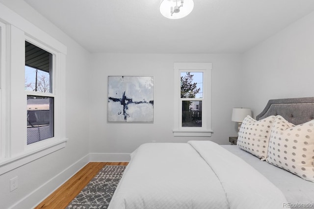 bedroom with baseboards and wood finished floors