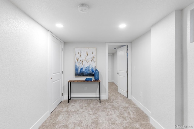 hallway featuring carpet flooring and baseboards