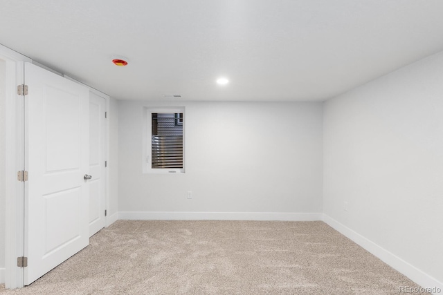 spare room featuring recessed lighting, baseboards, and light carpet