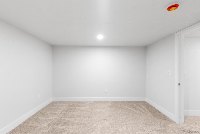 unfurnished room with baseboards and light colored carpet