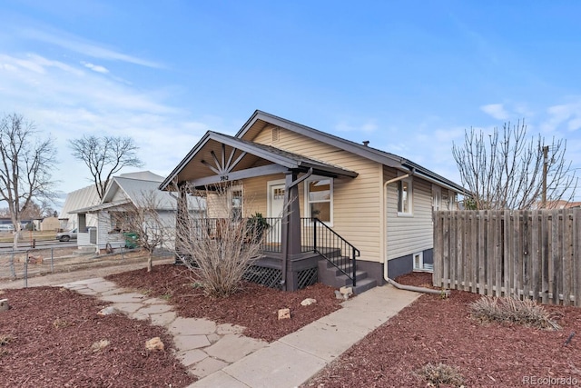 bungalow-style house featuring a porch and fence