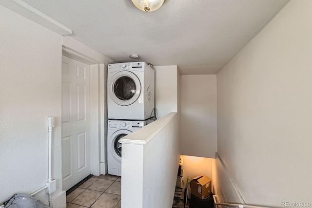 washroom with stacked washer and dryer and light tile patterned flooring