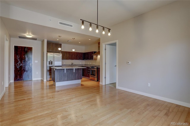 kitchen featuring stainless steel appliances, a center island, open floor plan, and visible vents