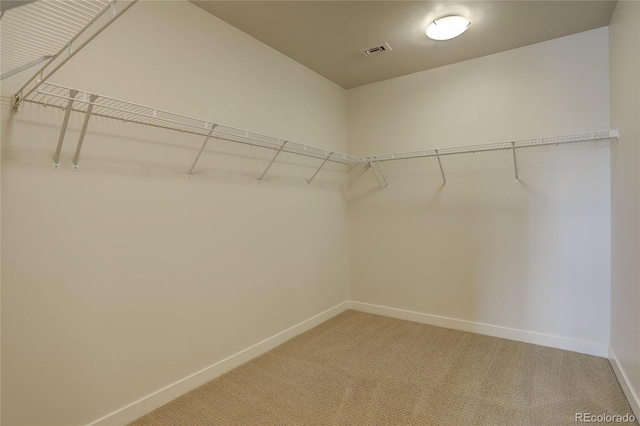 walk in closet with light colored carpet and visible vents