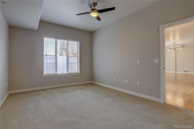 unfurnished room with light carpet, ceiling fan, baseboards, and vaulted ceiling