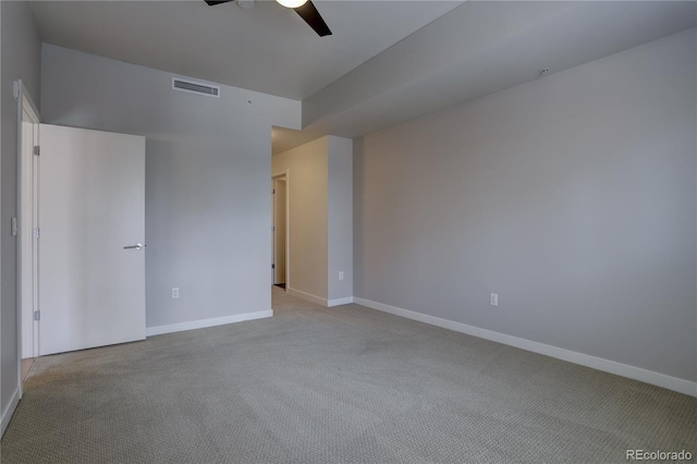 carpeted empty room with a ceiling fan, visible vents, and baseboards