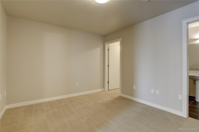 carpeted empty room featuring baseboards