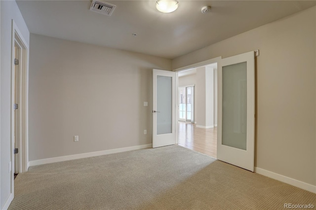 spare room with french doors, visible vents, baseboards, and carpet flooring