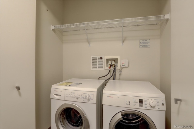 washroom featuring laundry area, visible vents, and independent washer and dryer