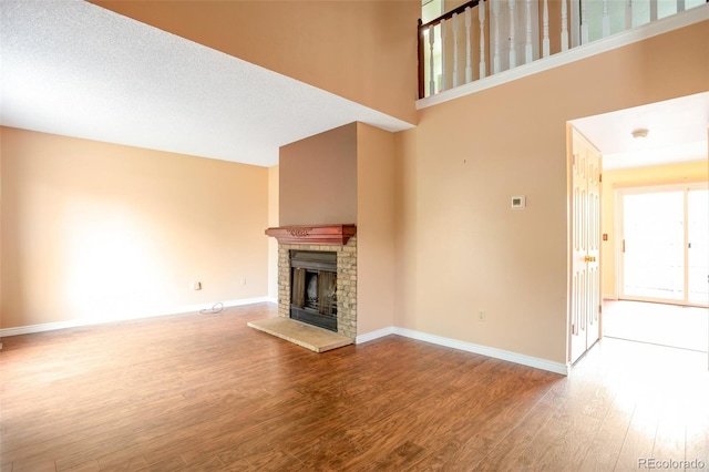 19421 E Milan Cir, Aurora, CO 80013 - unfurnished living room featuring wood finished floors, a fireplace, and baseboards