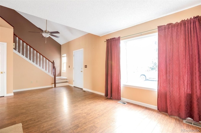 19421 E Milan Cir, Aurora, CO 80013 - unfurnished living room featuring wood finished floors, ceiling fan, stairs, vaulted ceiling, and baseboards