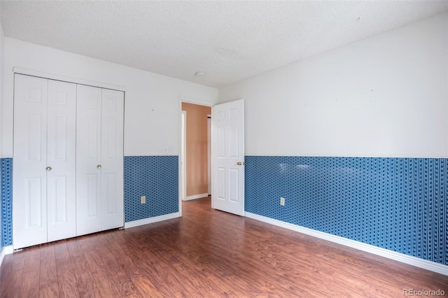 19421 E Milan Cir, Aurora, CO 80013 - unfurnished bedroom featuring wainscoting, wood finished floors, a closet, baseboards, and a textured ceiling