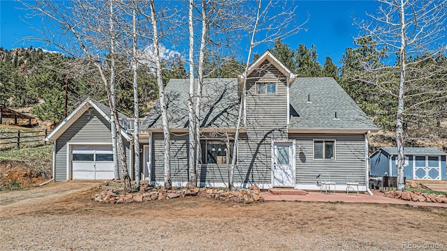 view of front facade featuring a shed and a garage