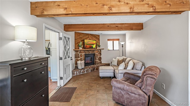 living room featuring beam ceiling and a stone fireplace