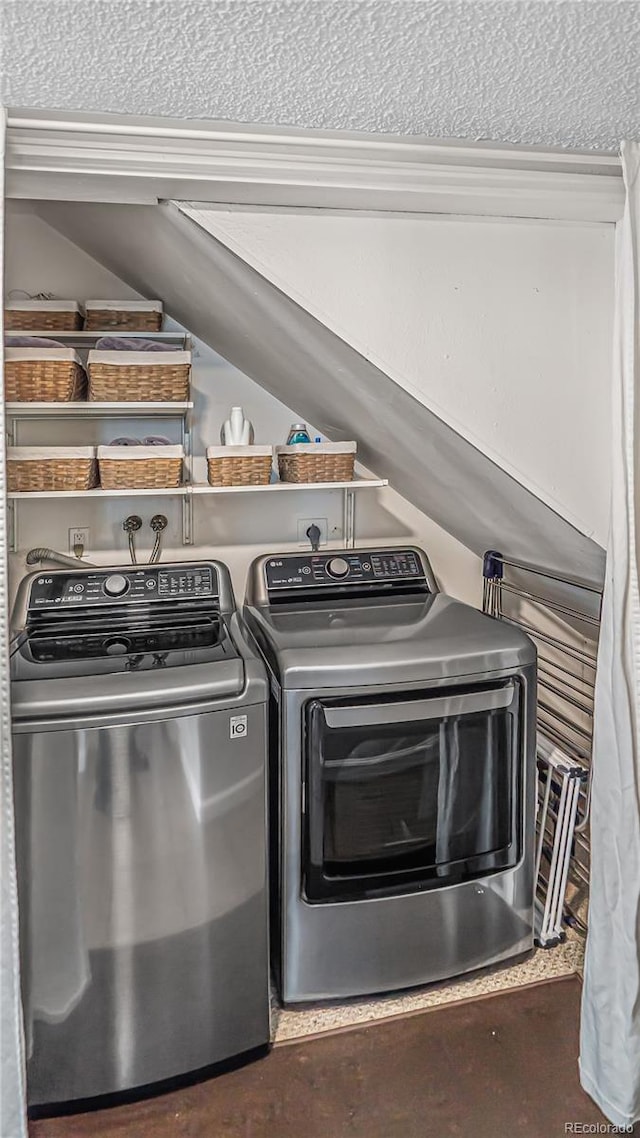 laundry area with washing machine and dryer and a textured ceiling